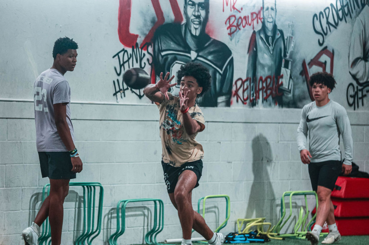 Dre Muhammad coaching a wide receiver on the field